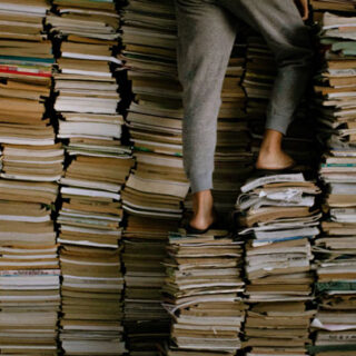 Person climbing on stacks of books