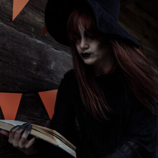 photo of woman dressed as witch holding a book