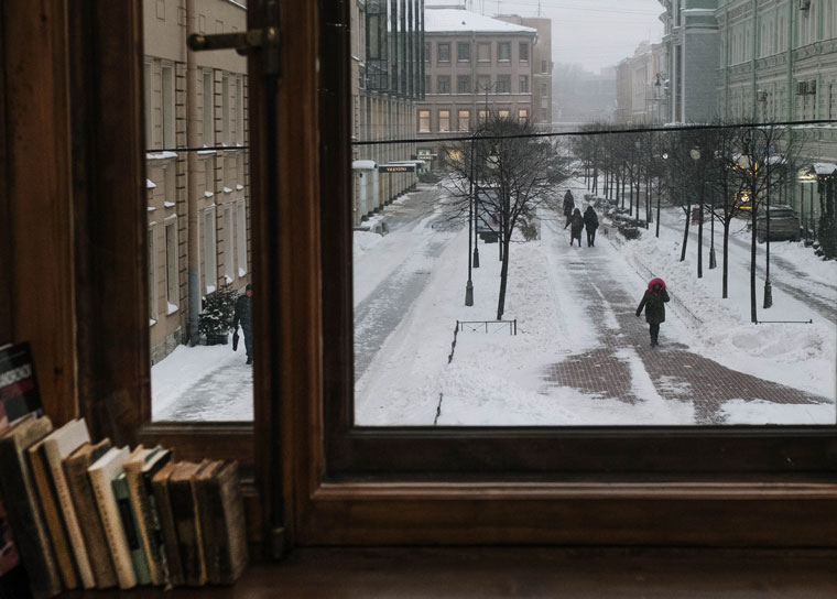 Photo from window of snow on street with books inside